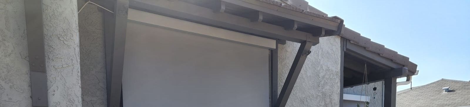 Exterior view of the motorized roller shades fully lowered, providing shade and privacy for the South Pasadena residence